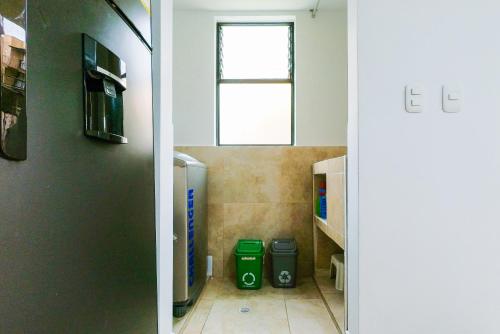 - une salle de bains avec deux poubelles vertes dans la chambre dans l'établissement Hábitat Blue Sky La Tebaida, à La Tebaida