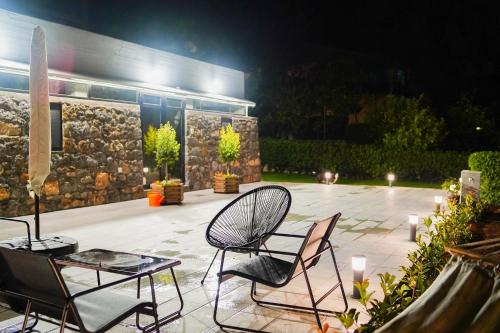 a patio with two chairs and a table and lights at Lemon Tree Villa in Chalkida