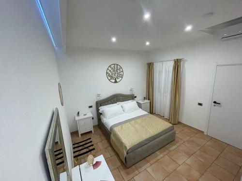 a bedroom with a bed and a clock on the wall at la Maison del Mas Gold in Elmas