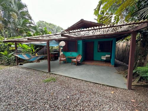 a blue house with a porch with a swing at Mono Azul Cahuita in Cahuita