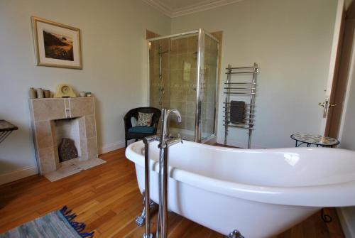 a bathroom with a tub and a glass shower at Bayview- relaxing home by the sea in Saint Monance