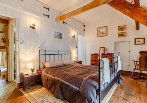 a bedroom with a bed and a wooden floor at Alpha Cottage in Dittisham