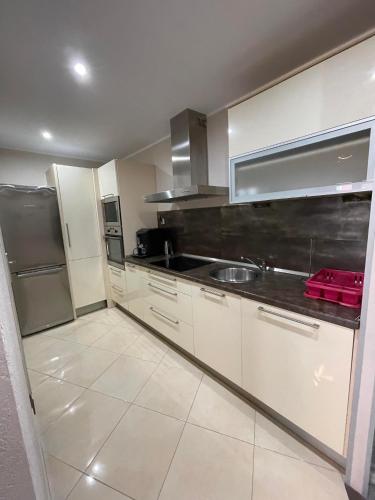 une cuisine avec des armoires blanches et des appareils en acier inoxydable dans l'établissement Apartament CALMA I, à Krynica Morska