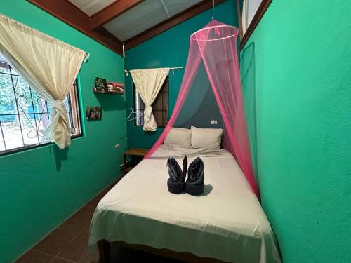 a pair of shoes sitting on a bed in a room at Mono Azul Cahuita in Cahuita