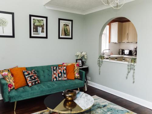 a living room with a green couch and a table at Beautiful apartment in Guildford with parking in Send