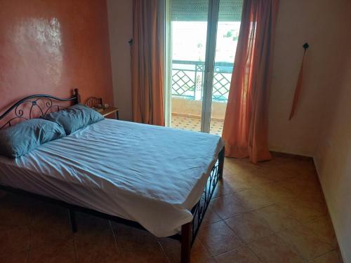 アル・ジャディーダにあるPalmier sidi Bouzidのベッドルーム1室(青いシーツと窓付)