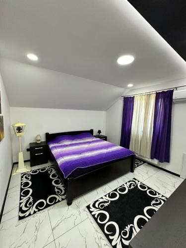 a bedroom with a purple bed and two rugs at Vila Veselić in Valjevo