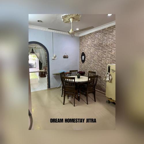 a dining room with a table and chairs and a brick wall at Homestay Jitra Dream Homestay in Jitra