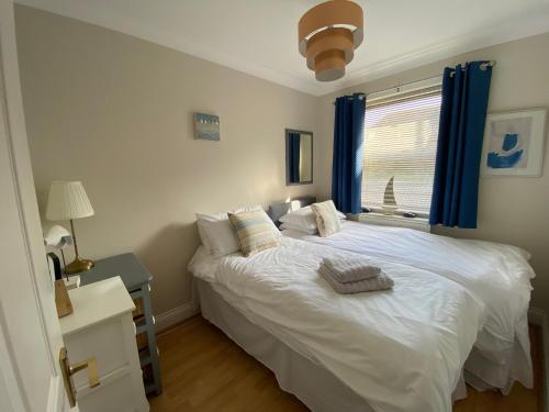 a bedroom with a white bed and a window at Harbour Mews Central Location Near Beach in Whitstable