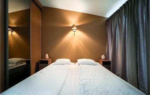 um quarto com uma grande cama branca com luzes na parede em Bungalowpark Wijdland - Aak em Bunschoten