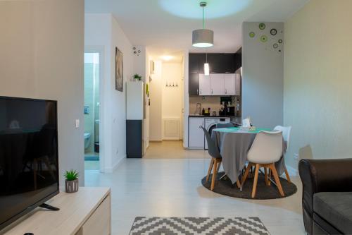 a living room with a table and a kitchen at GviTown Central Apartment in Bucharest