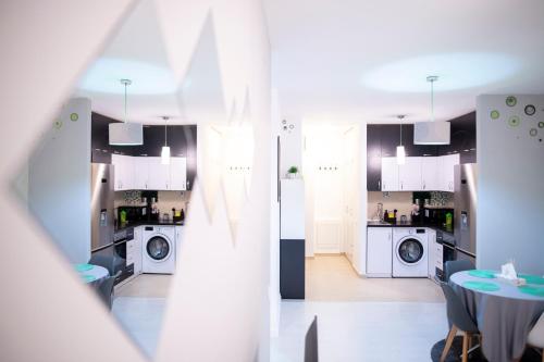 a kitchen with washing machines and a table in a room at GviTown Central Apartment in Bucharest