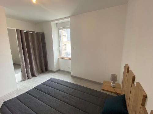 un salon avec un canapé et une fenêtre dans l'établissement Résidence de la poste, à Saint-Pol-de-Léon