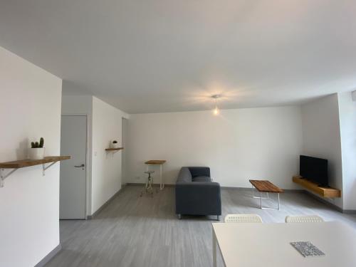 un salon avec un canapé et une télévision dans l'établissement Résidence de la poste, à Saint-Pol-de-Léon