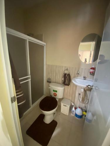 a small bathroom with a toilet and a sink at Blue House - Via a la costa in Guayaquil