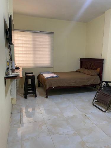 a bedroom with a bed and a desk in it at Blue House - Via a la costa in Guayaquil