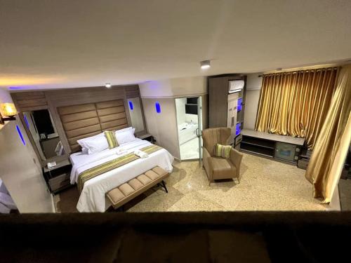 een grote slaapkamer met een groot bed en een stoel bij Ikeja Airport View in Lagos