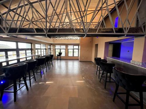 a large room with chairs and a bar with blue lights at Ikeja Airport View in Lagos