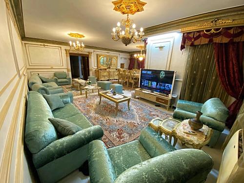 a living room with green couches and a television at LuXury Apartment Nasr City - CityStars in Cairo