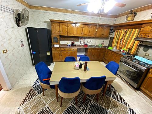 a kitchen with a table and blue chairs at LuXury Apartment Nasr City - CityStars in Cairo