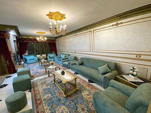 a living room with blue couches and a chandelier at LuXury Apartment Nasr City - CityStars in Cairo
