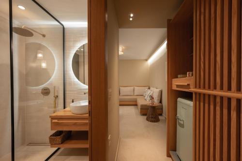 a bathroom with a sink and a shower and a toilet at Trinity Design Suites in Valanidorachi