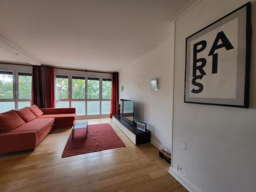 ein Wohnzimmer mit einem roten Sofa und einem TV in der Unterkunft Spacious Apartment near Paris, for Family and Friends in Montrouge