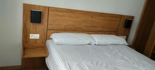 Schlafzimmer mit einem Bett mit einem Kopfteil aus Holz in der Unterkunft The Oxygen 9 in Tétouan