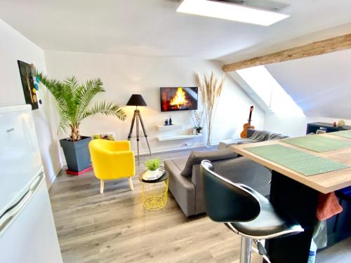 een woonkamer met een bank en een tafel bij Beau duplex à deux pas du port in Le Tréport