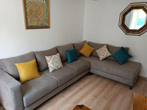 ein graues Sofa mit bunten Kissen im Wohnzimmer in der Unterkunft The Oxygen 9 in Tétouan