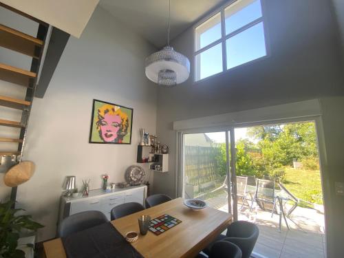 une salle à manger avec une table et une grande fenêtre dans l'établissement Chambre avec salle de bain privée à l étage dans ma maison, à Bourges