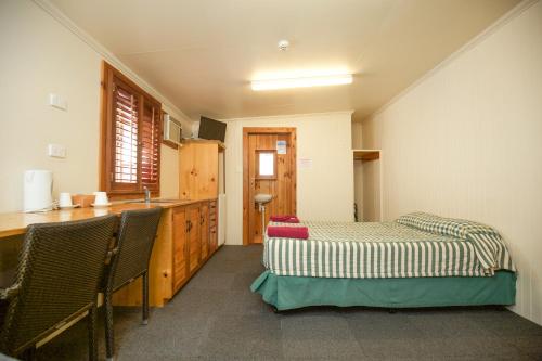 a kitchen with two beds and a sink in a room at Brisbane Manor in Brisbane