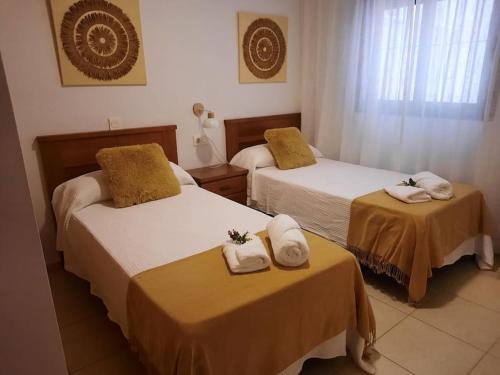 a hotel room with two beds with towels on them at Apartamento en Torre del Mar in Torre del Mar