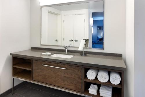 a bathroom with a sink and a mirror at Courtyard Edison Woodbridge in Edison