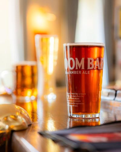 a glass of beer sitting on a wooden table at The George Hotel in Axminster