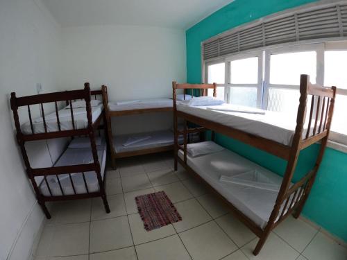 Ce dortoir comprend 2 lits superposés et une fenêtre. dans l'établissement Casarão hostel, à Arraial do Cabo