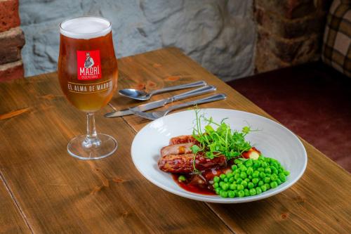 a plate of food and a glass of beer on a table at The George Hotel in Axminster