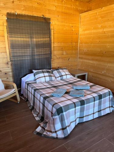 a bedroom with a bed in a wooden room at Granja escuela con bungalows Familias y grupos Parking privado gratuito in San Martín de la Vega