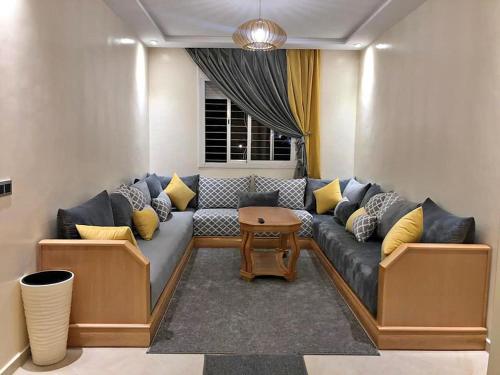 a living room with a couch and a table at Annakhil appartement in Rabat