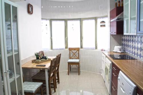 uma cozinha com mesa, cadeiras e janelas em Canteras Bliss em Las Palmas de Gran Canaria