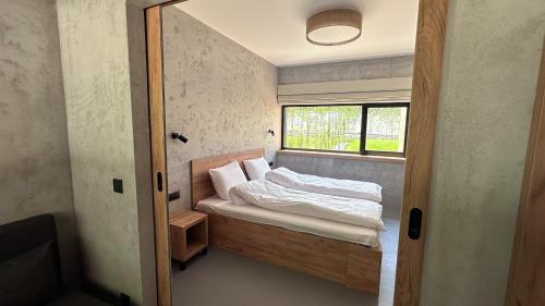 - une petite chambre avec un lit et une fenêtre dans l'établissement Mana Lake, à Sieraków