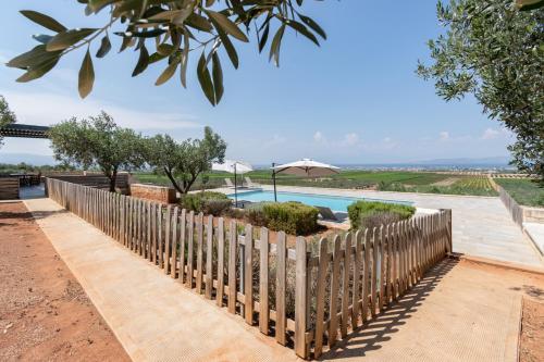 a wooden fence in front of a pool at The Olive Hill in Ássos