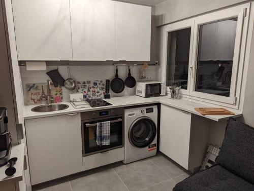 a kitchen with a washing machine and a sink at Charming Studio with Eiffel View in Paris