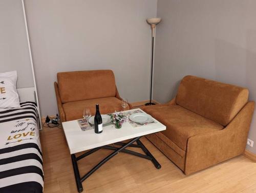Cette chambre comprend une chaise et une table avec une bouteille de vin. dans l'établissement Charming Studio with Eiffel View, à Paris