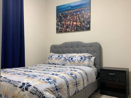 a bedroom with a bed with a picture on the wall at 1 bedroom apartment in Halifax