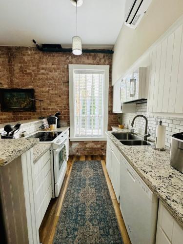 a kitchen with white appliances and a brick wall at Bisbee Brownstone Suites in Bisbee