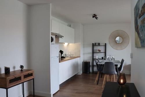 a kitchen and a dining room with a table at Les Cottages chaleureux avec une terrasse cosy in Biscarrosse