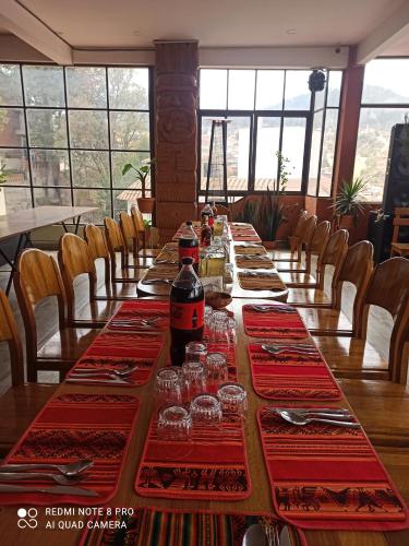 einen langen Tisch mit Weinflaschen und Gläsern darauf in der Unterkunft Santa Pacha in Sucre