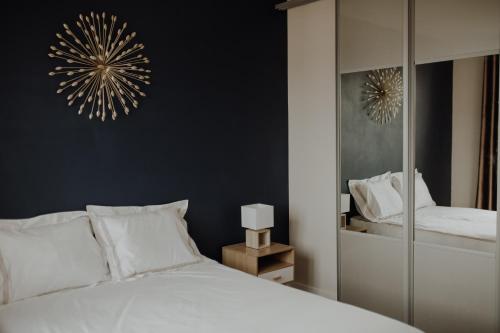 ein Schlafzimmer mit einem weißen Bett und einem Spiegel in der Unterkunft Superbe appartement rénové - Salon de Provence in Salon-de-Provence