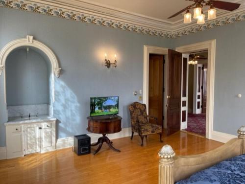 a living room with a bed and a tv in it at Upjohn in Kalamazoo